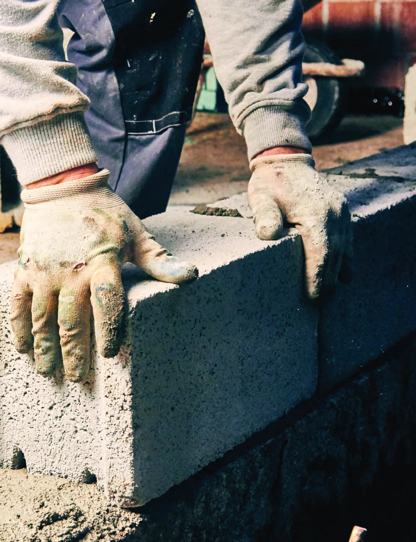 A builder placing a masonry block during construction