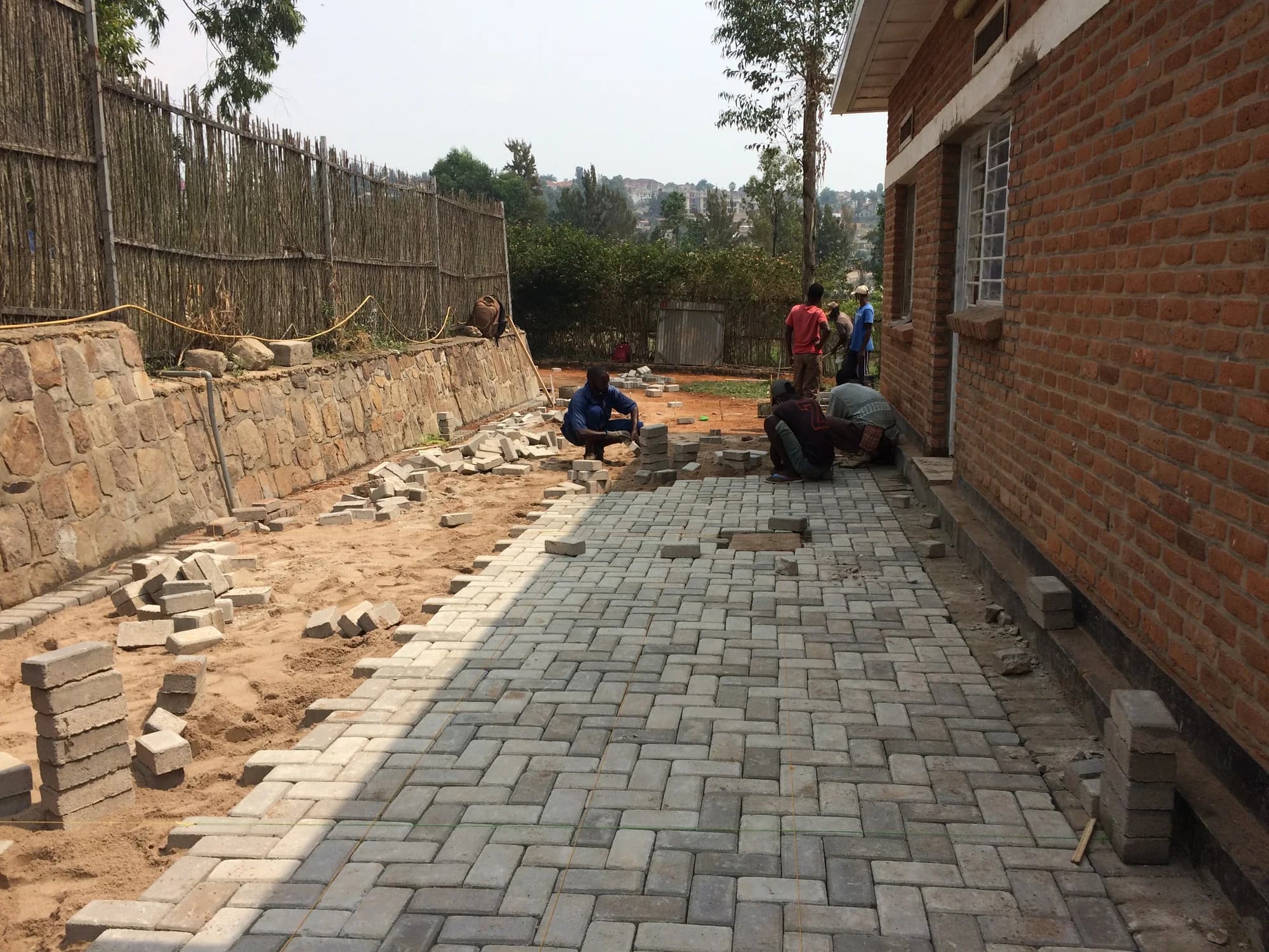 Local builders laying the permeable paved walk between the guesthouse and its stone garden wall