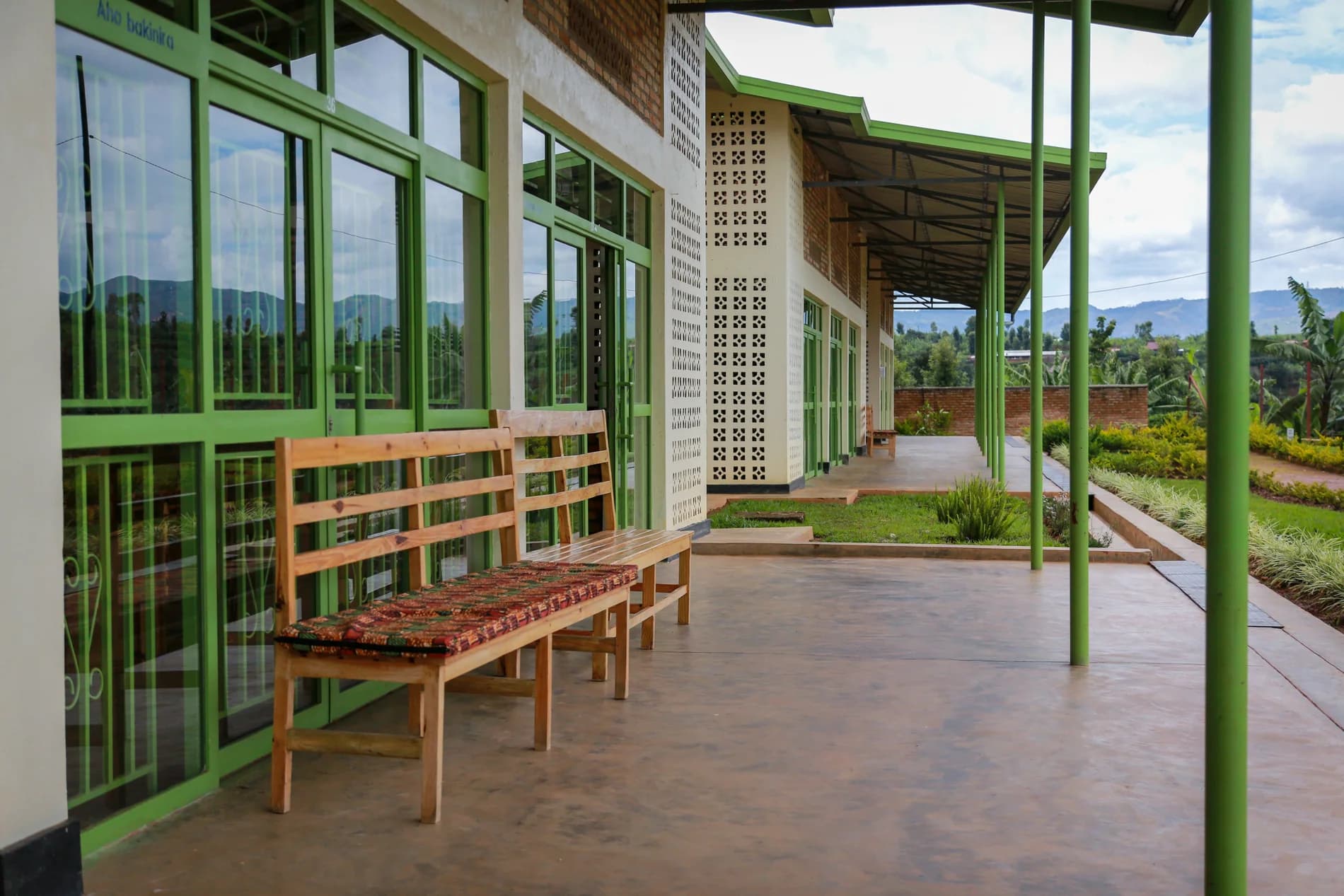 The completed ASFA center's wide covered walkway, green-framed treatment rooms, and landscaped garden