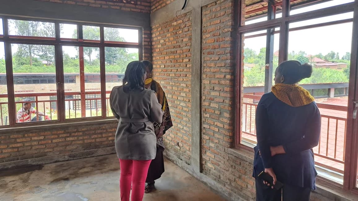 An unfinished brick guestroom opening toward the courtyard through broad windows