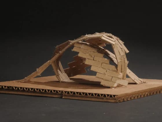 Cardboard concept model exploring how the cafeteria's brick shells weave together as floor, walls, and roof