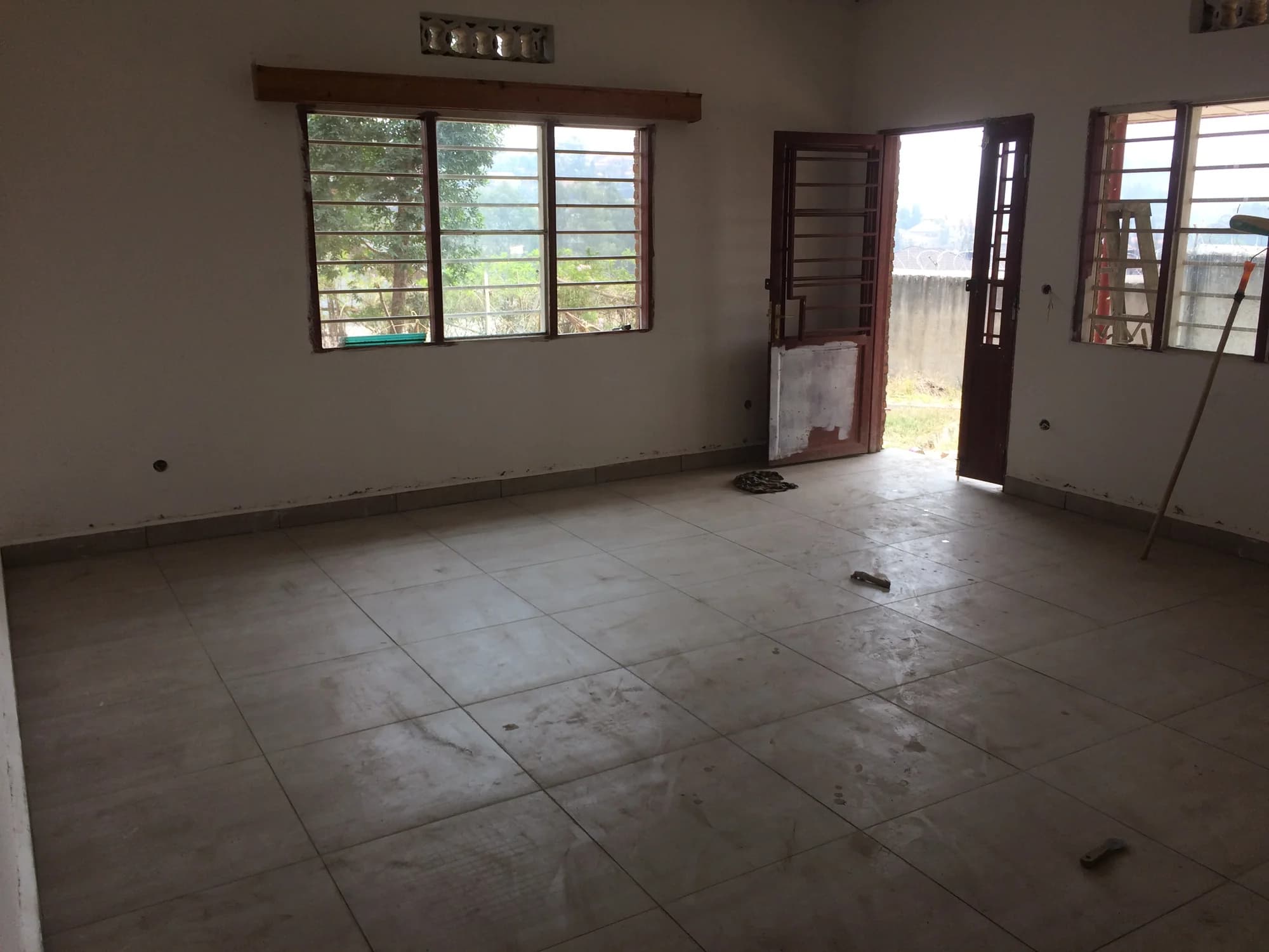 A renovated guesthouse room with tiled floors, cross-ventilating windows, and direct access outside