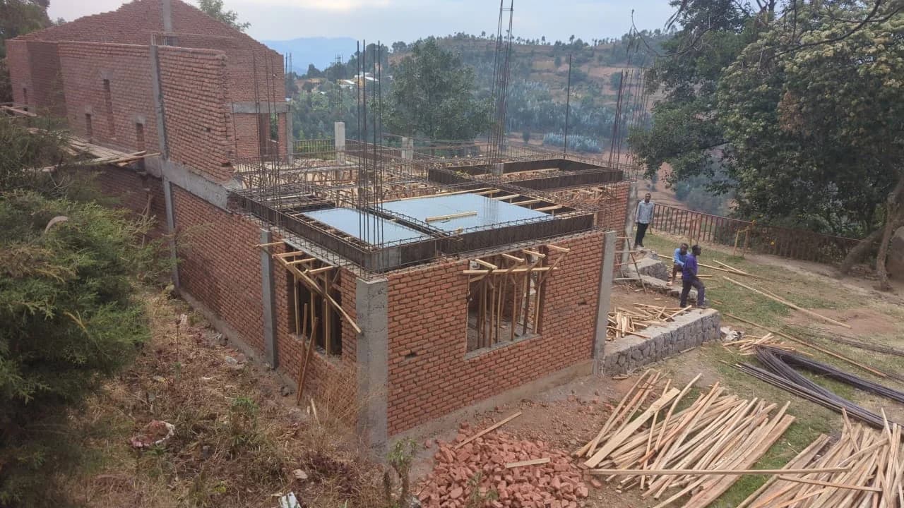 Brick walls and reinforced-concrete framing establish the multipurpose center beside Sunzu's existing community buildings